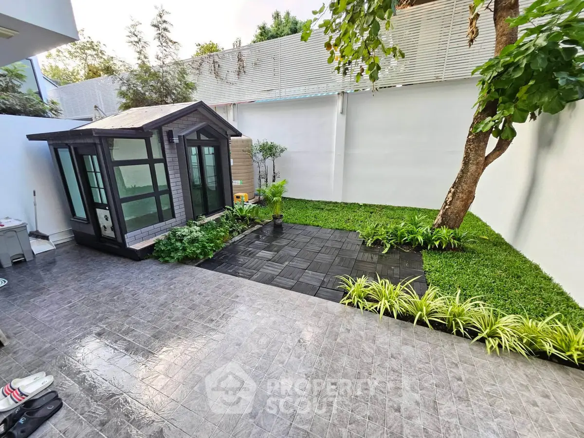 Charming backyard with modern shed and lush greenery, perfect for relaxation and outdoor activities.