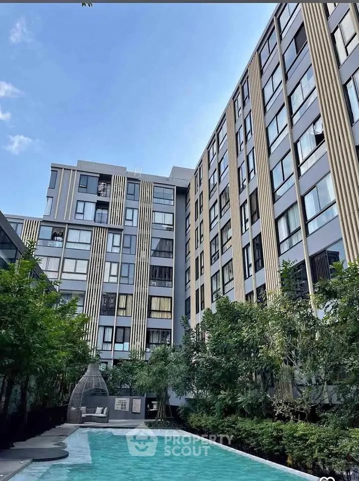 Modern apartment building with pool and lush greenery, perfect for urban living.