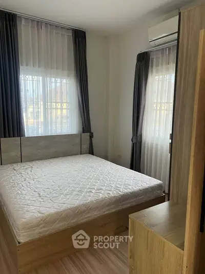 Cozy bedroom with natural light and modern furnishings, perfect for relaxation.