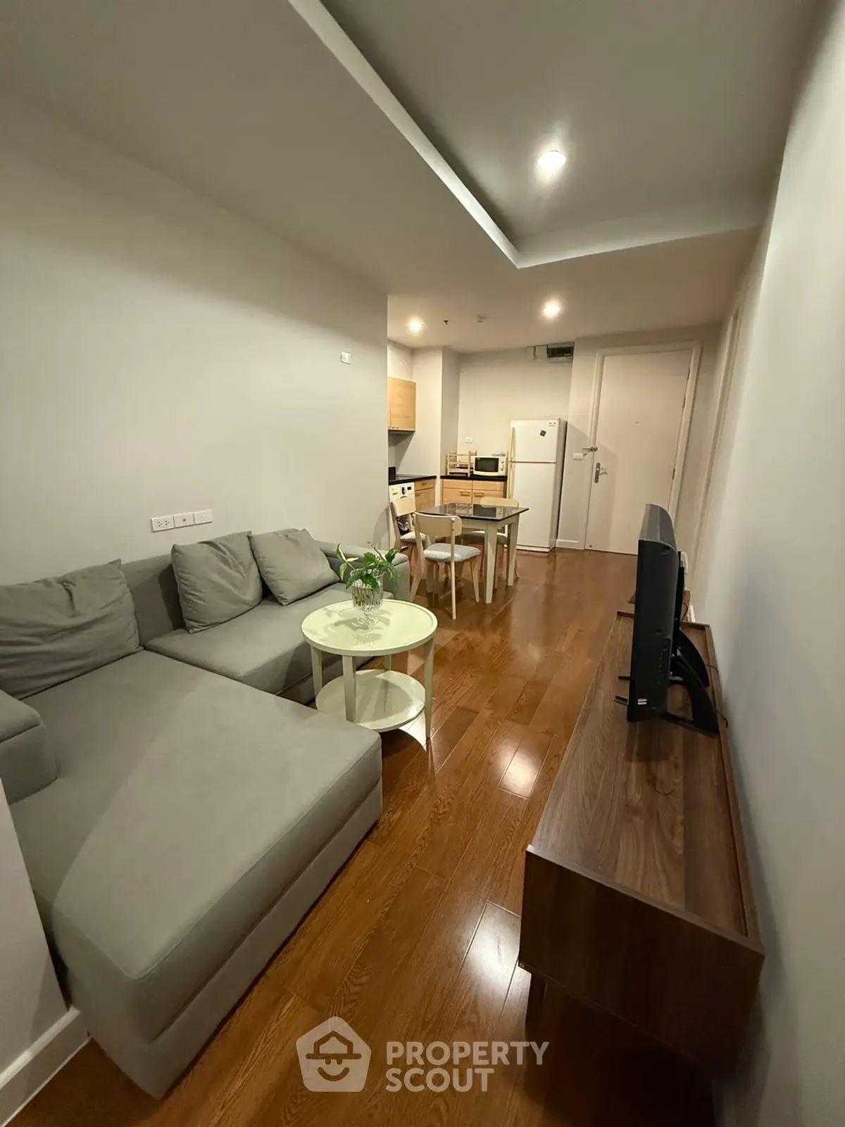Modern living room with cozy gray sofa and wooden flooring