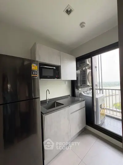 Modern kitchen with sleek cabinetry and balcony view