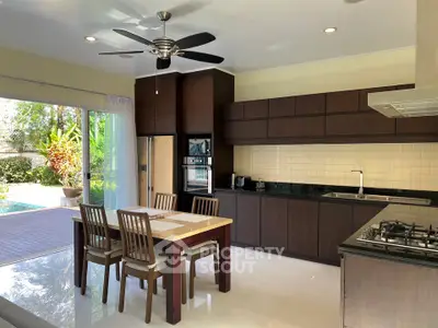 Spacious kitchen with open layout and garden view, featuring modern appliances and dining area.