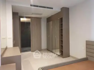 Modern bedroom with sleek built-in wardrobe and neutral tones, perfect for minimalist living.