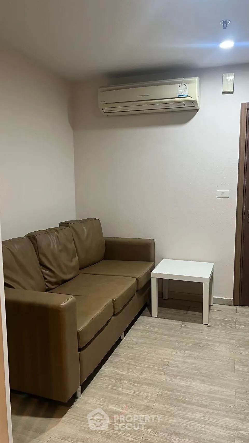 Cozy living room with brown leather sofa and air conditioning