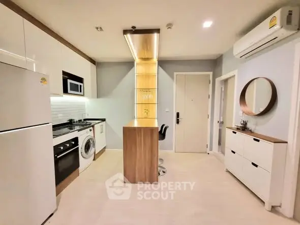 Modern kitchen with sleek appliances and stylish cabinetry in a compact layout.