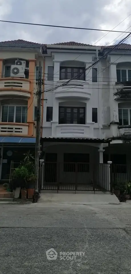 Charming townhouse exterior with gated entrance and classic architecture.