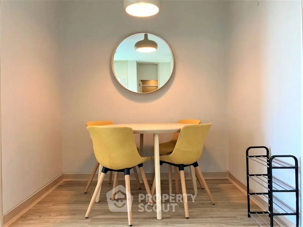 Chic dining nook with modern yellow chairs and round mirror
