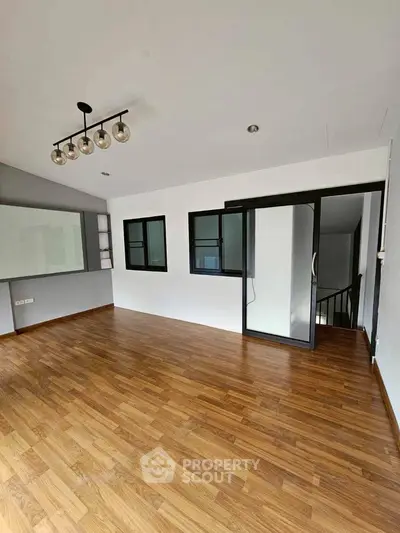 Modern empty room with wooden flooring and stylish lighting