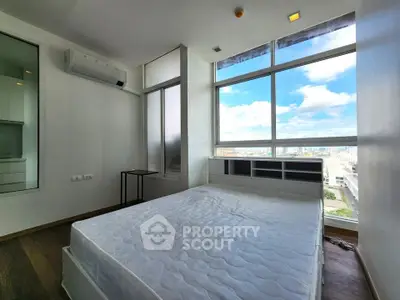Bright bedroom with large window offering stunning city views, featuring modern air conditioning and minimalist design.