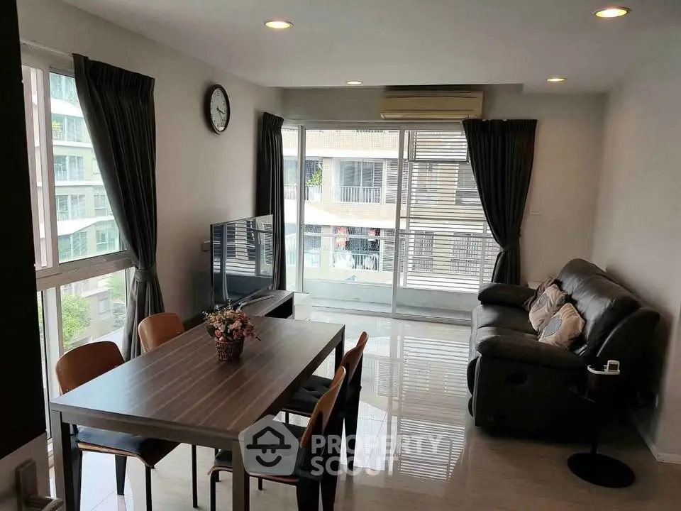 Spacious living room with modern furniture and large windows offering natural light.
