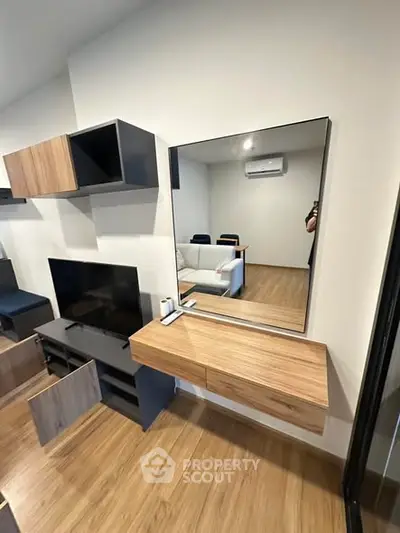 Modern living room with sleek wooden furniture and wall-mounted TV