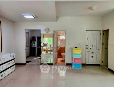 Spacious modern living area with open kitchen and colorful storage, ideal for family living.