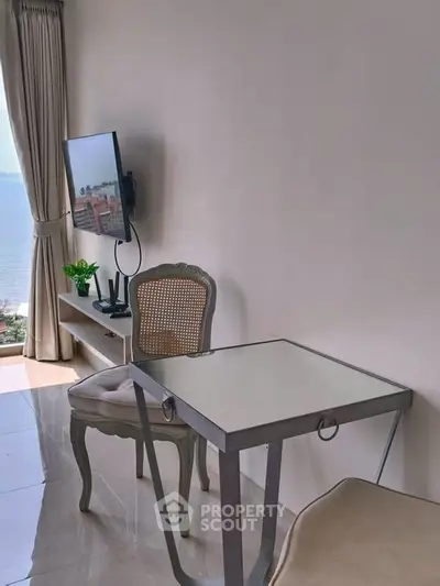 Chic modern living room with ocean view, elegant furniture, and wall-mounted TV for a luxurious lifestyle.