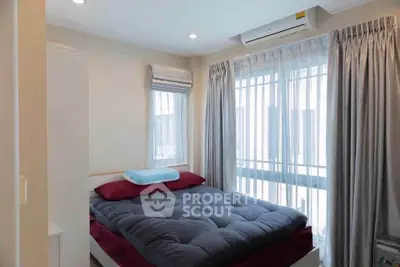 Cozy bedroom with large window and modern air conditioning unit, perfect for relaxation.