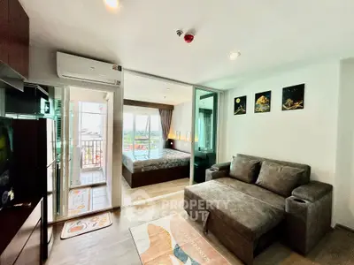 Modern apartment with cozy living room and bedroom, featuring a balcony with a view.