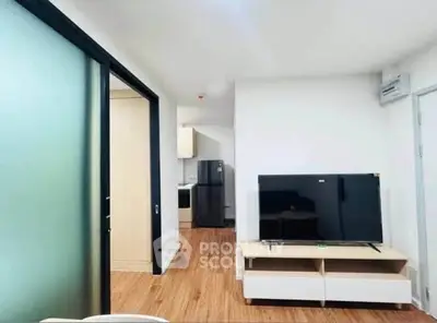 Modern living room with sleek TV setup and open kitchen view