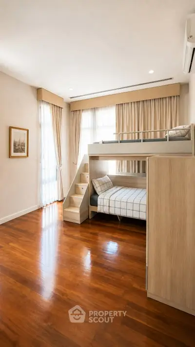 Spacious bedroom with bunk bed and wooden flooring, perfect for family living.