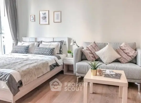 Modern bedroom with cozy bed and stylish sofa in bright, airy space.