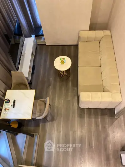Modern living room with stylish beige sofa and elegant dining area, perfect for cozy gatherings.