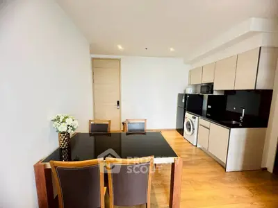 Modern kitchen and dining area with sleek appliances and wooden flooring