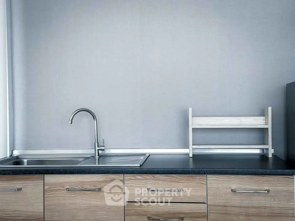 Modern minimalist kitchen with sleek faucet and wooden cabinetry