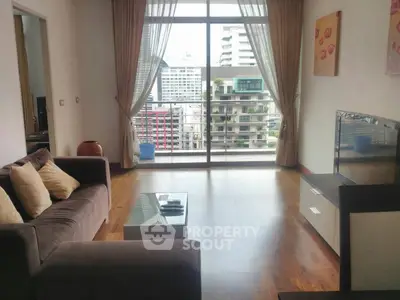 Spacious living room with modern decor and city view balcony, perfect for urban living.