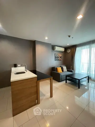 Modern living room with open kitchen and sleek design in a stylish apartment.