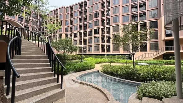 Modern apartment building with lush garden and water feature