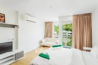 Bright modern bedroom with balcony and scenic view, featuring minimalist decor and natural light.