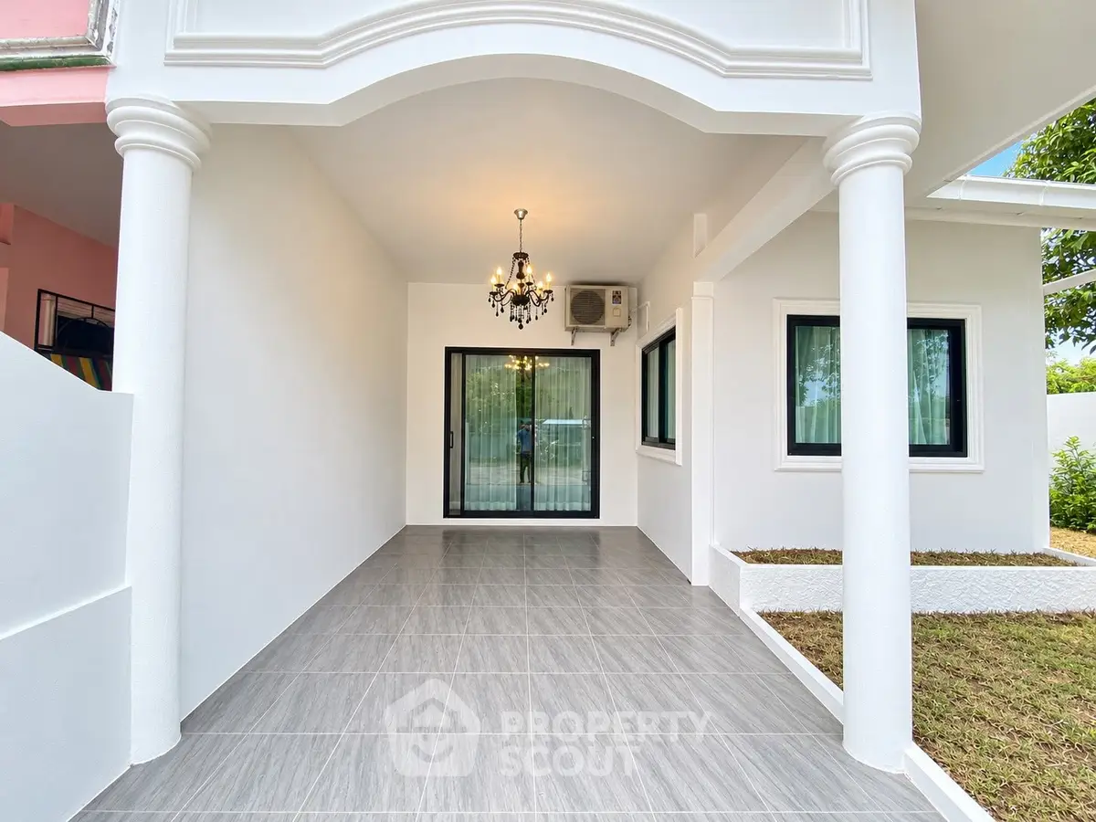 Elegant modern house entrance with chandelier and sliding glass doors