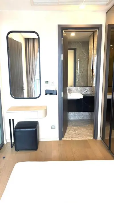 Modern bedroom with ensuite bathroom featuring elegant design and natural light.