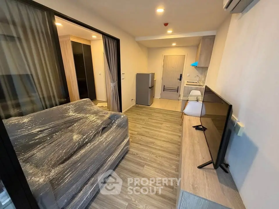 Modern living room with sleek furniture and open kitchen layout in a stylish apartment.