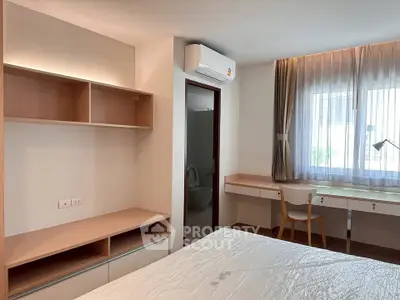 Modern bedroom with built-in shelves, desk, and air conditioning, perfect for a cozy living space.