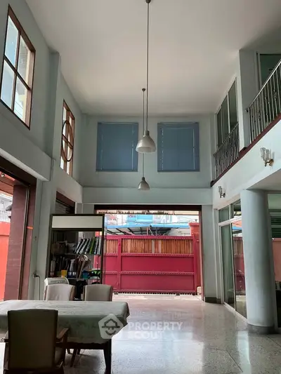 Spacious two-story living room with high ceilings and large windows, offering ample natural light and modern design.