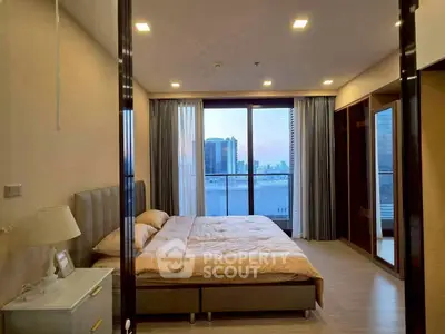 Luxurious bedroom with city view and modern furnishings in high-rise apartment.