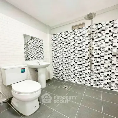Modern bathroom with stylish black and white tiles and sleek fixtures.