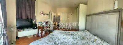 Spacious bedroom with modern decor and ample natural light, featuring a cozy bed and stylish furnishings.