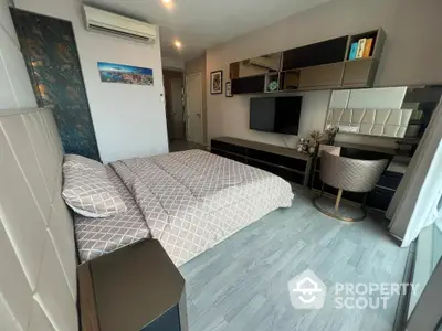 Modern studio apartment with a cozy bedroom area featuring a large bed, sleek furniture, and a well-organized living space with contemporary decor.