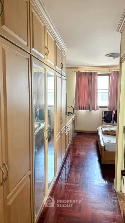 Cozy bedroom with wooden flooring and built-in mirrored wardrobe