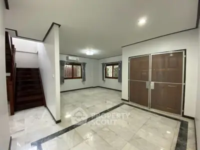 Spacious living room with marble flooring and wooden accents in modern home.