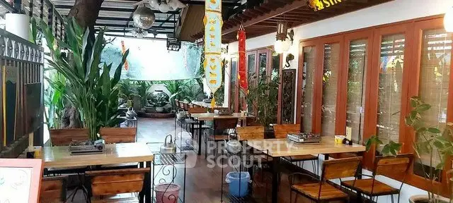 Charming outdoor dining area with lush greenery and wooden furniture