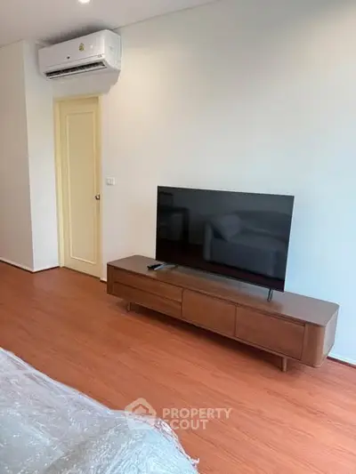 Modern living room with sleek TV setup and wooden flooring