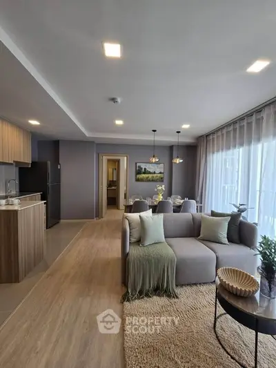 Modern open-plan living room with cozy seating and stylish kitchen
