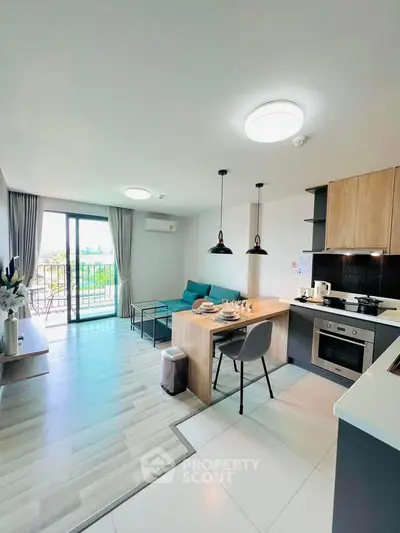Modern open-plan living room with kitchen, featuring stylish decor and a balcony view.