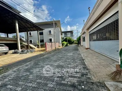 Charming residential street with modern buildings and clear blue sky.