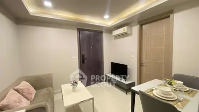 Modern living room with cozy sofa, dining area, and wall-mounted TV in a stylish apartment.