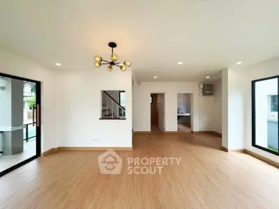 Spacious modern living room with elegant lighting and large windows in a contemporary home.