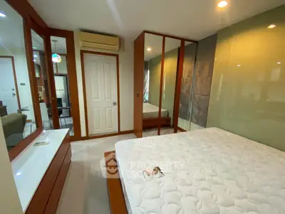 Spacious bedroom with mirrored wardrobe and modern air conditioning unit