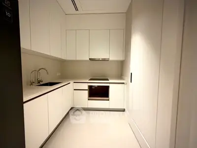 Modern kitchen with sleek white cabinetry and built-in appliances in a contemporary apartment.