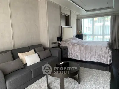 Luxurious bedroom with elegant decor and cozy seating area in modern apartment.